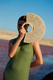 MUJER MODELANDO CON BOLSO DE PAJA EN FORMA DE MEDIA LUNA