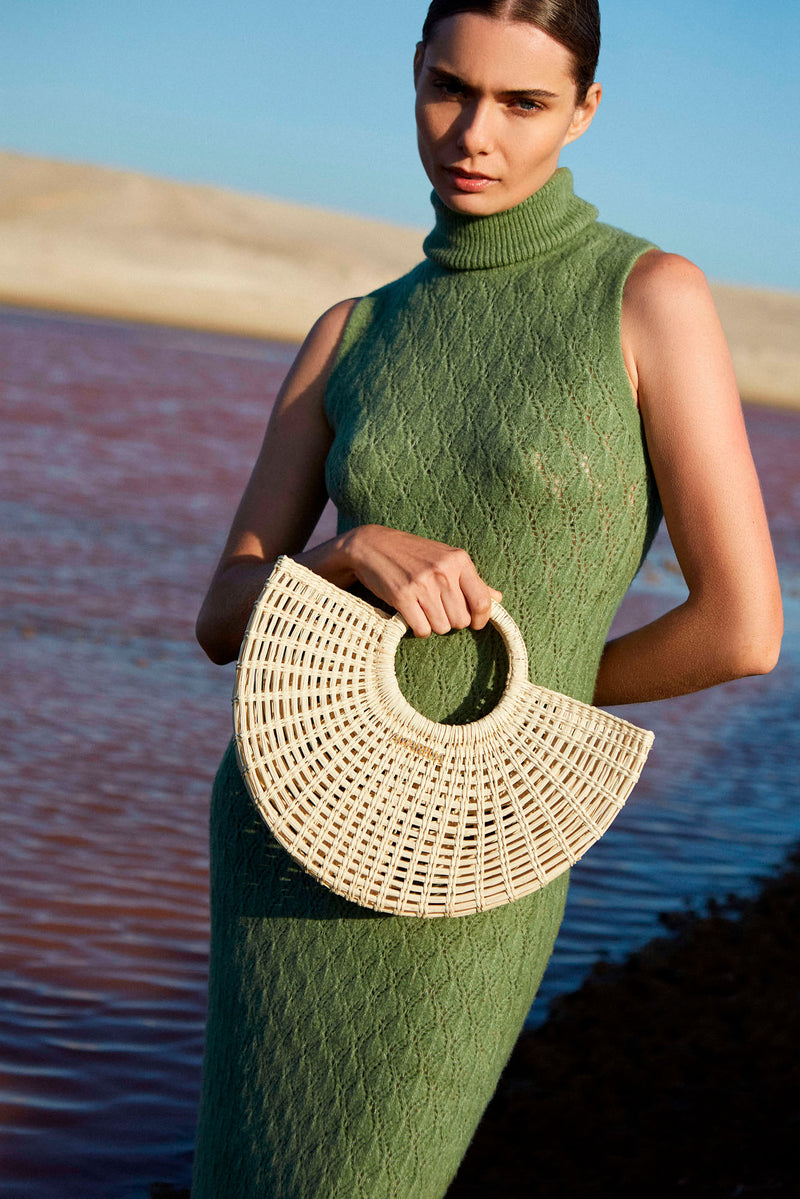 MUJER MODELANDO CON BOLSO DE PAJA EN FORMA DE MEDIA LUNA